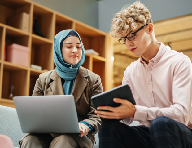 Junger Mann und Frau schauen auf Tablet